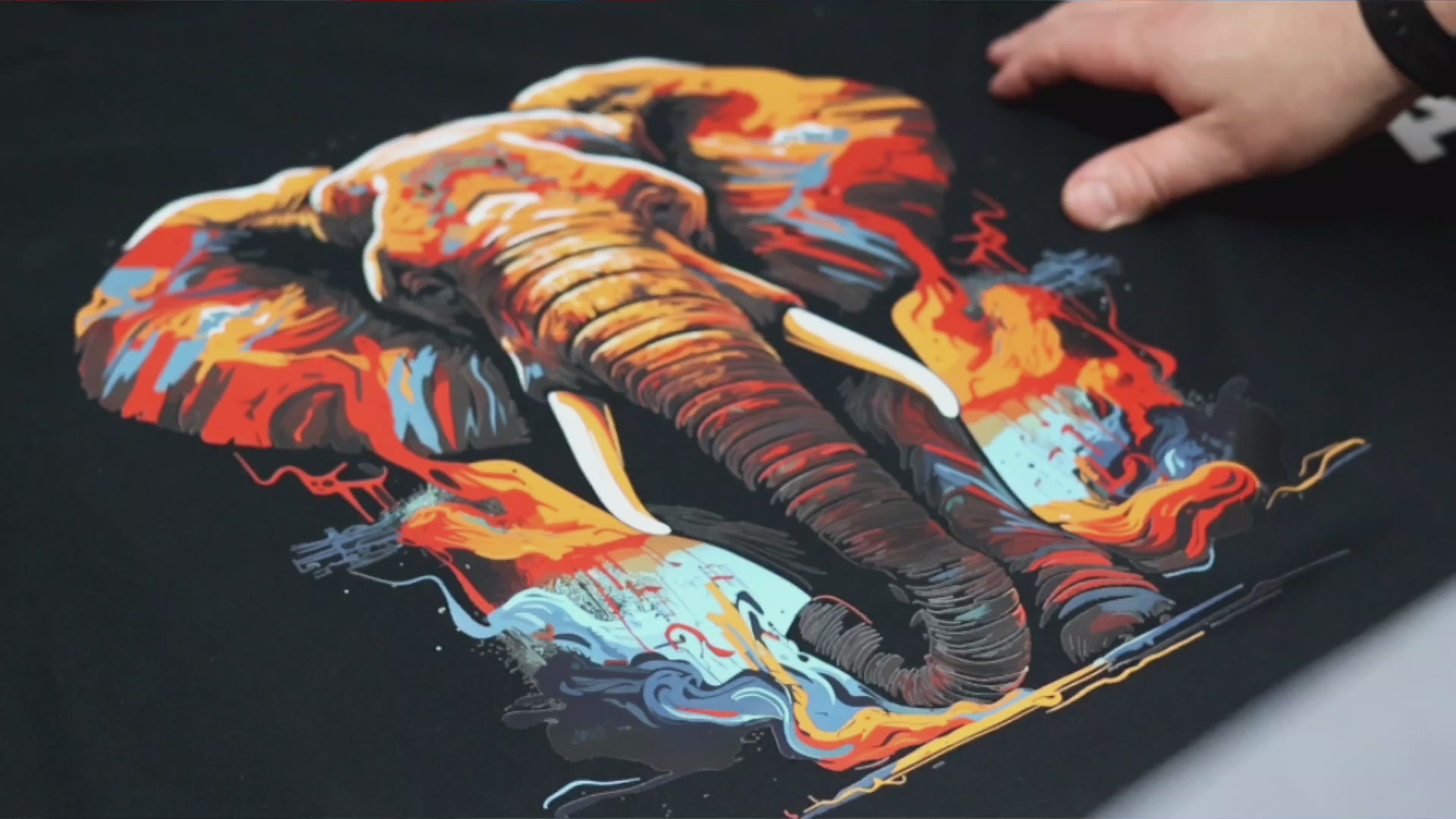 Load video: Peeling a transfer sheet of a t-shirt depicting an elephant in water colors